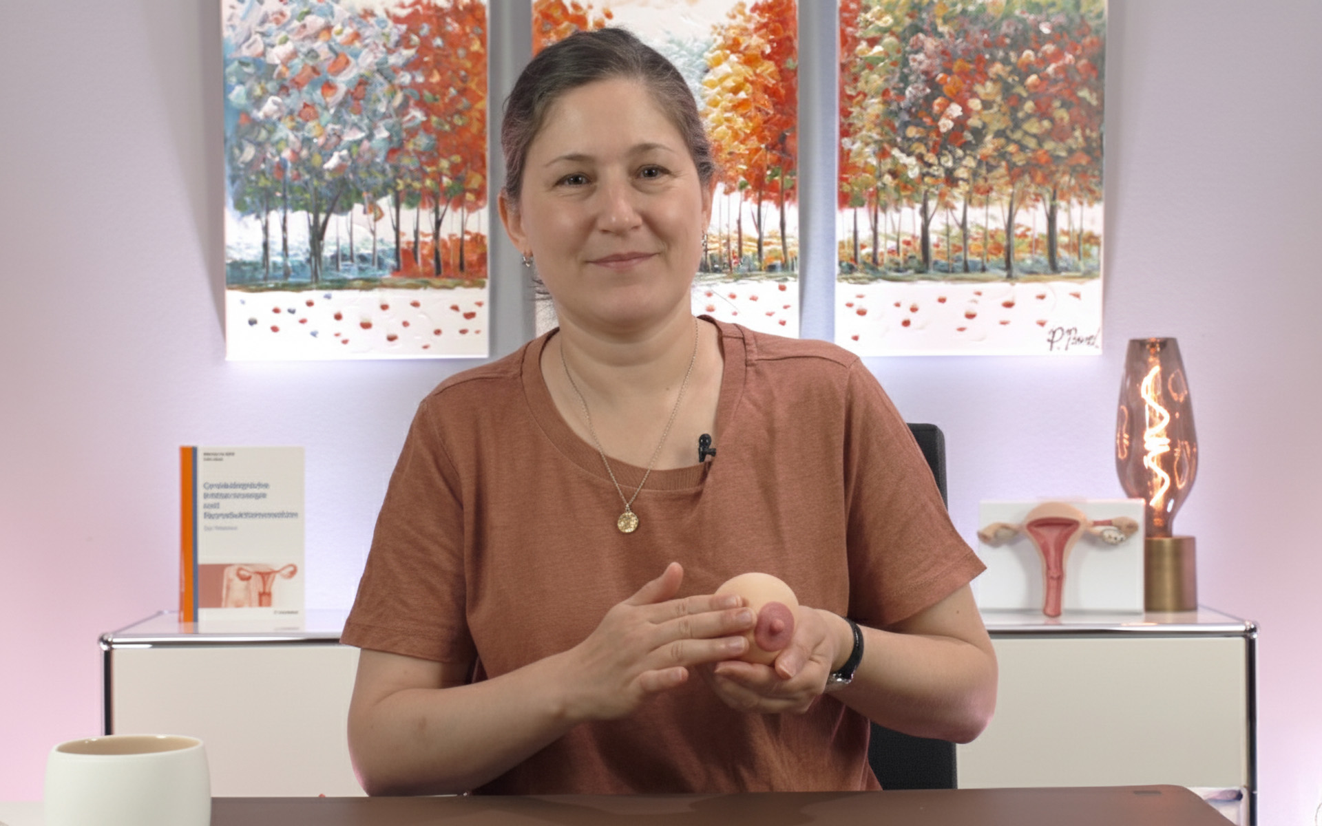 Frau Dr. Stindt hält eine Kunststoff-Nachbildung einer Brust in der Hand, um das Ausstreichen zu demonstrieren